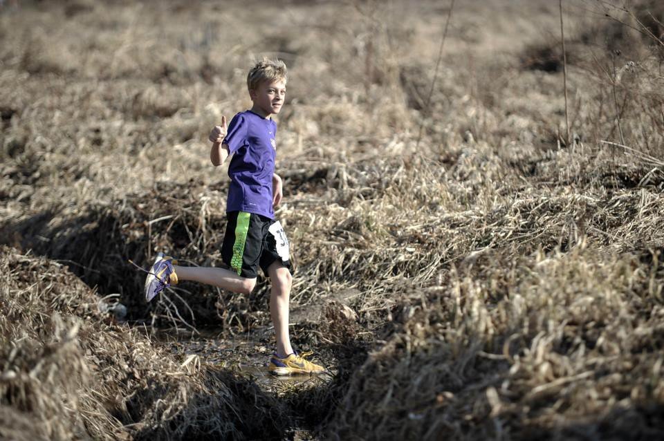 Nine-year old Rheinhardt gives a thumbs up on a cross country run.